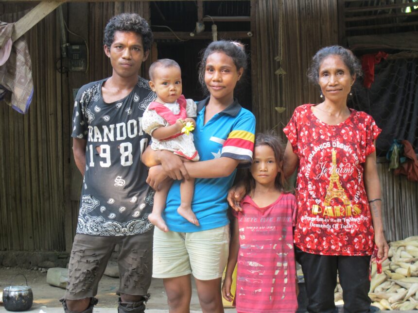 Timorese family of five standing outside their home - Action on Poverty