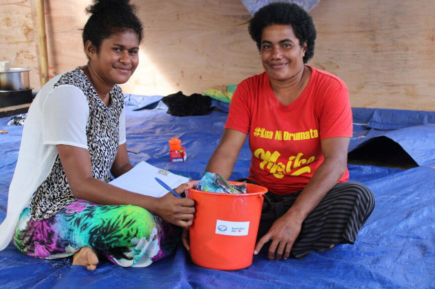 Two smiling women with a bucket of hygiene supplies in Fiji - Action on Poverty