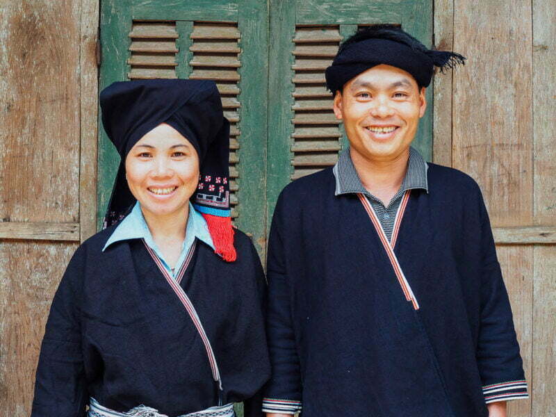 Nhat and Quy in traditional Dao dress outside their homestay