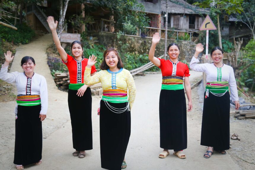 Women waving guests in Da Bac CBT